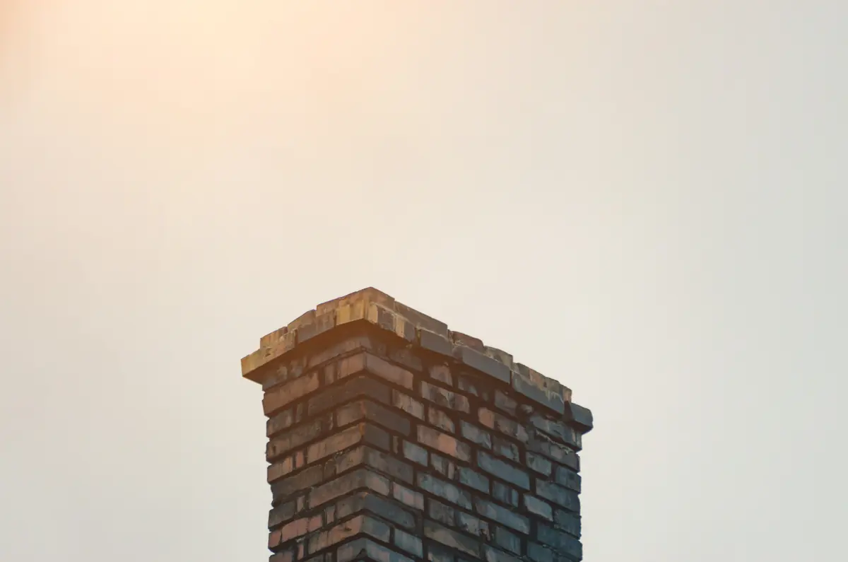 A brick chimney top against a pale sky