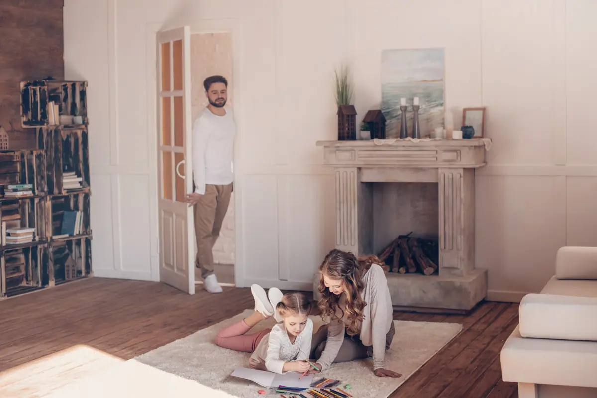 A family relaxing in a living room with a fireplace