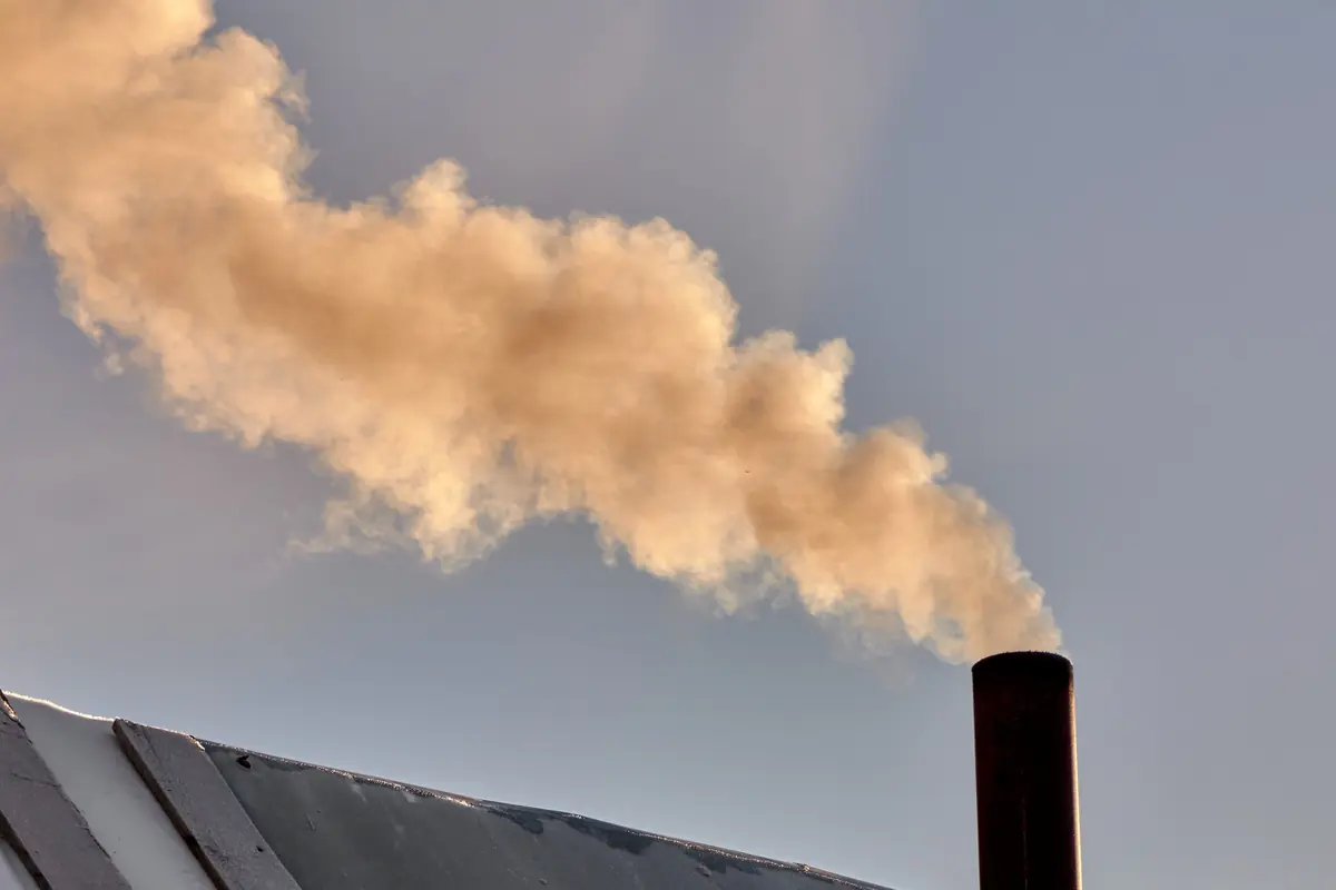 A plume of smoke rising from a chimney flue